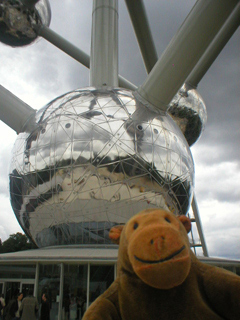 Mr Monkey looking at the base and lower sphere of the Atomium