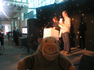 Mr Monkey watching Roger McKinley receive his award