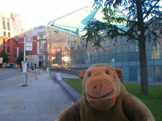 Mr Monkey looking at the sun reflected on the side of Urbis