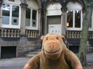 Mr Monkey looking at a plaque on the wall of the Crown