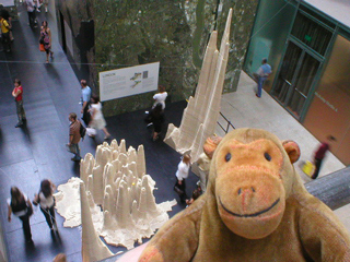 Mr Monkey looking down on cities represented as mountain ranges