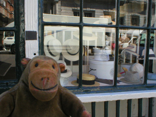 Mr Monkey looking into a hat shop on St James Street