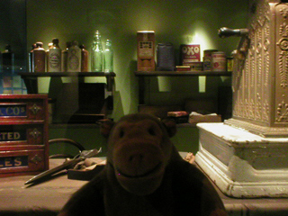Mr Monkey looking at a display of shop equipment