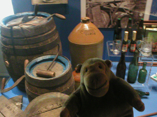 Mr Monkey looking at a display of beer barrels and bottles