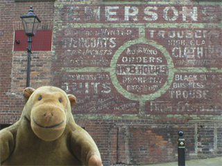 Mr Monkey looking at an old advert on the side of Blackshaw's cafe