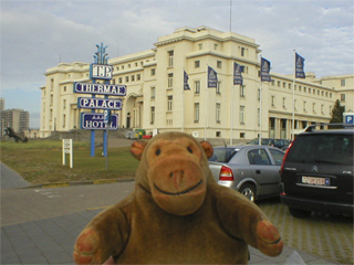 Mr Monkey looking at the Thermae Palace Hotel from the street