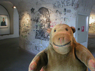 Mr Monkey looking at graffiti in the upper floor barracks of Fort Napoleon