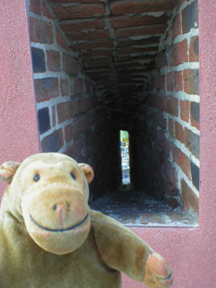 Mr Monkey looking through a gunslit on the roof of Fort Napoleon
