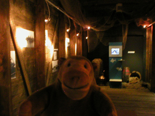 Mr Monkey looking at photos in a replica of the first fish-mine