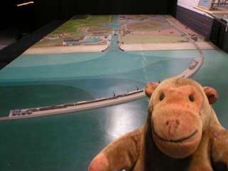Mr Monkey looking at a model of the port of Zeebrugge in the 1930s