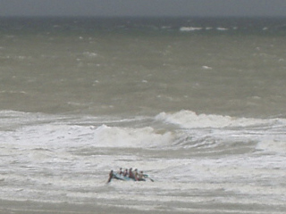 A small boat trying to leave the beach