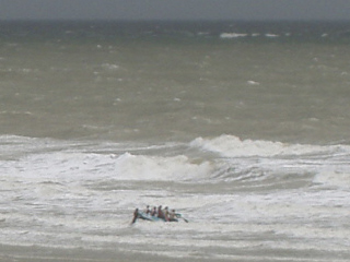 A small boat trying to leave the beach