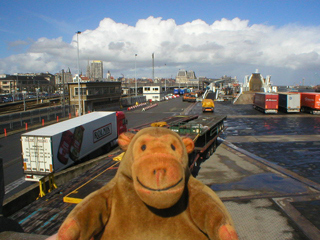 Mr Monkey watching container trucks lining up to board a ferry