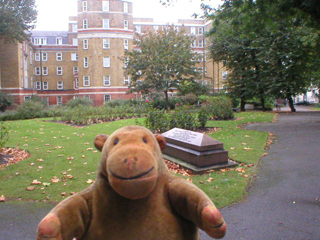 Mr Monkey looking at a tomb in a garden off Gray's Inn Road