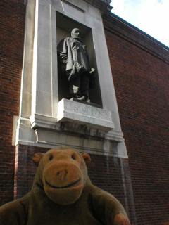 Mr Monkey looking up at a statue of Shackleton
