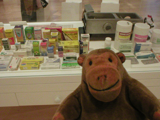 Mr Monkey looking at a display of malaria treatments