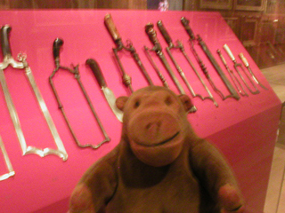 Mr Monkey looking at a collection of surgical saws