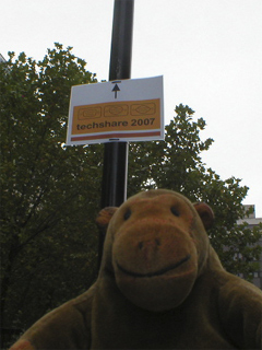 Mr Monkey looking at a sign announcing the TechShare conference