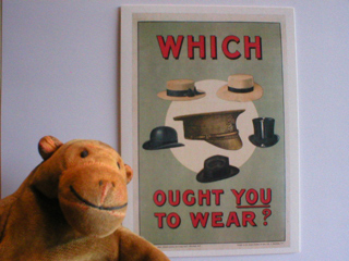 Mr Monkey looking at a poster showing hats with the slogan Which Ought You To Wear?