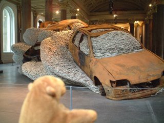 Mr Monkey looking at large stack of papers and burned out cars