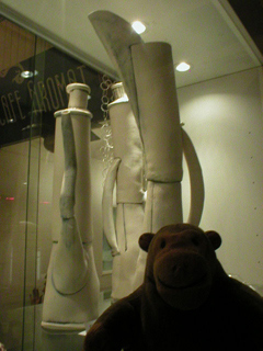 Mr Monkey looking at tall thin coffee pots by Stella Lahav