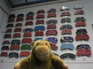 Mr Monkey looking at a wall of train nameplates