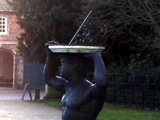A statue of a slave holding a sundial