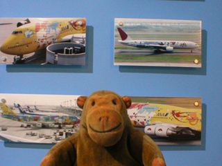 Mr Monkey looking at pictures of aircraft decorated with Pokemon characters