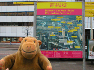 Mr Monkey examining a plan of work being done around Rotterdam Central station