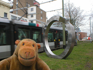 Mr Monkey looking at a sculpture of a broken ring