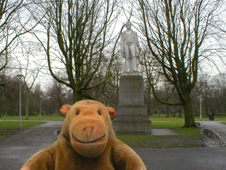 Mr Monkey looking at a statue of Hendrik Tollens