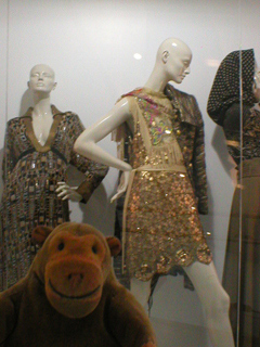 Mr Monkey looking at a 2006 gold sequin dress and a 2005 Nasa bead dress