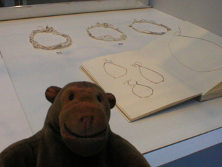 Mr Monkey looking at bracelets and a notebook