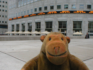 Mr Monkey watching Stock Exchange prices outside a cafe