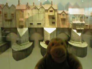 Mr Monkey looking at a model of London Bridge in 1450