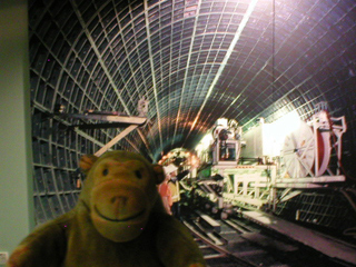 Mr Monkey looking at a picture of the building of the Jubilee line 