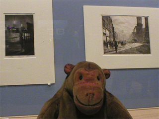 Mr Monkey looking at a pair of prints by Martin Lewis