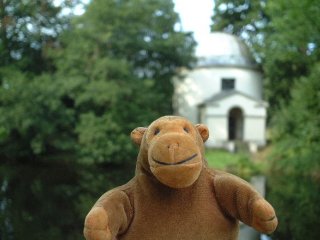 Mr Monkey the other side of a lake from a domed temple