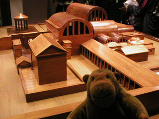 Mr Monkey examining a wooden model of the Roman temple complex