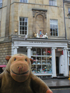 Mr Monkey looking at the ornate front of a chemists shop