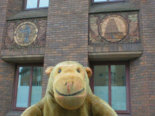 Mr Monkey looking at terracotta plaques on Broad Quay House