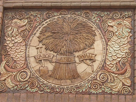 A wheatsheaf with the motto 'Labor and Wait'