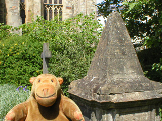 Mr Monkey looking at a tomb in the churchyard