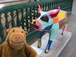 Mr Monkey looking at a pig painted with different coloured patches