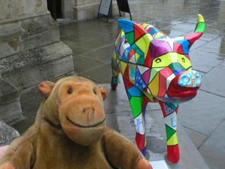 Mr Monkey looking at a pig decorated with small bright polygons