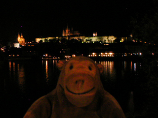 Mr Monkey looking at Prague Castle at night