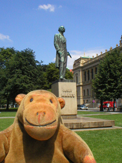 Mr Monkey looking at a statue of Josef Manes