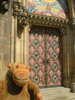 Mr Monkey looking at a side door of the church