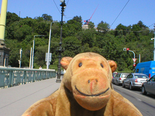 Mr Monkey looking at the Metronome from a car crossing Čhechův bridge