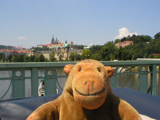 Mr Monkey looking at Prague Castle from a car crossing Čhechův bridge